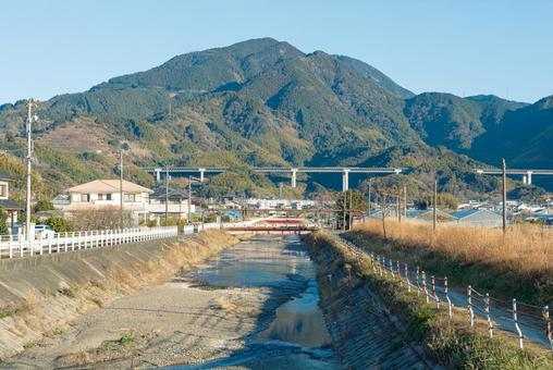 山をバックにした穏やかな流れの巴川 巴川,河川,川面の写真素材