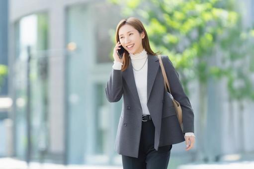 スマホで話す笑顔の女性・ビジネスウーマン 女性,スマホ,スマートフォンの写真素材