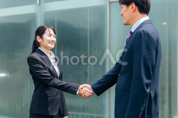 握手をするスーツ姿の男女（就活・大学生） 握手,契約,スーツの写真素材