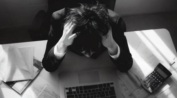 追い詰められた会社員・頭を抱えている 追い詰められた会社員・頭を抱えているの写真