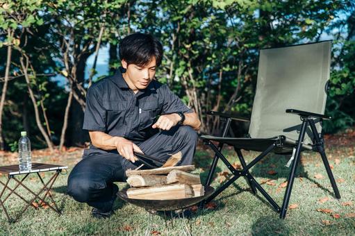 作業着を着てキャンプの準備をする男性 作業着を着てキャンプの準備をする男性 キャンプ,一人キャンプ,火おこしの写真素材