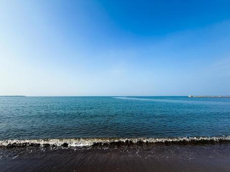 夏の青い海とビーチに打ち寄せる波 夏の青い海とビーチに打ち寄せる波の写真