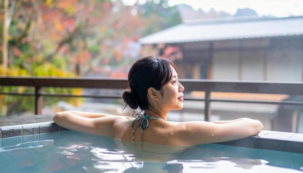 温泉につかってリラックスする若い女性 温泉につかってリラックスする若い女性の写真