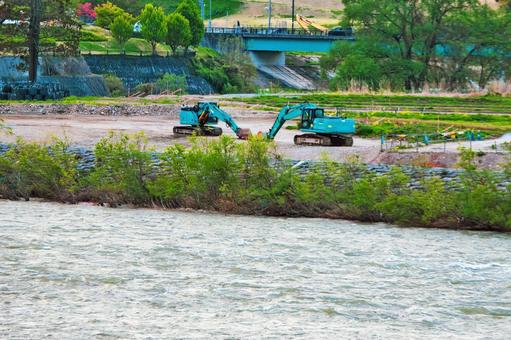 川辺にある二台の油圧ショベル 川,土木,工事の写真素材