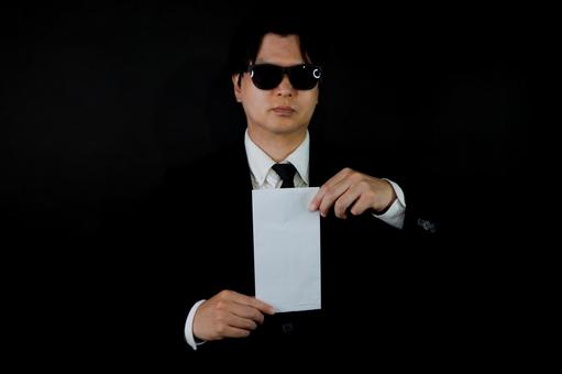 黒背景の封筒を持つ男性 黒背景の封筒を持つ男性 男性,封筒,黒背景の写真素材
