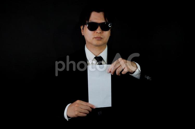 黒背景の封筒を持つ男性 男性,封筒,黒背景の写真素材