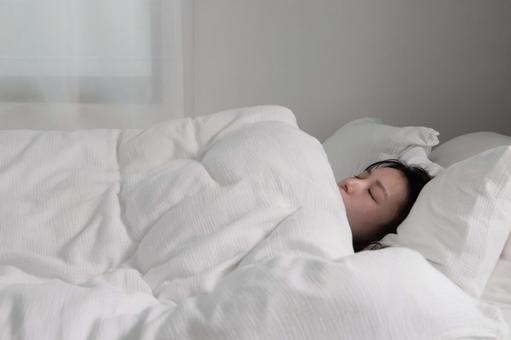 白いベッドで眠る女性 ベッド,布団,眠るの写真素材