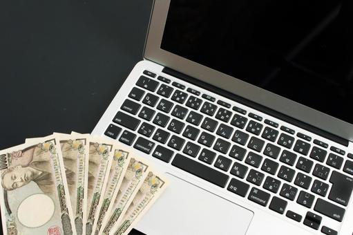 パソコンと日本円の札束 パソコンと日本円の札束 パソコン,ノートパソコン,キーボードの写真素材