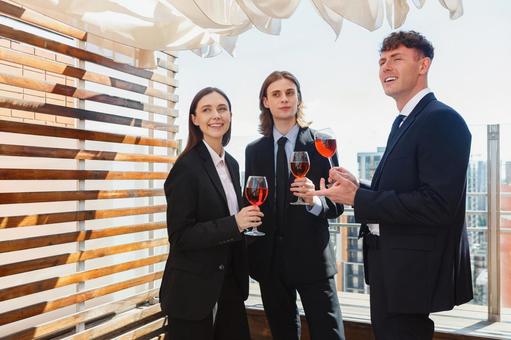 ワイングラスを持ち振り向く笑顔の外国人男女 男女,外国人,ビジネスの写真素材