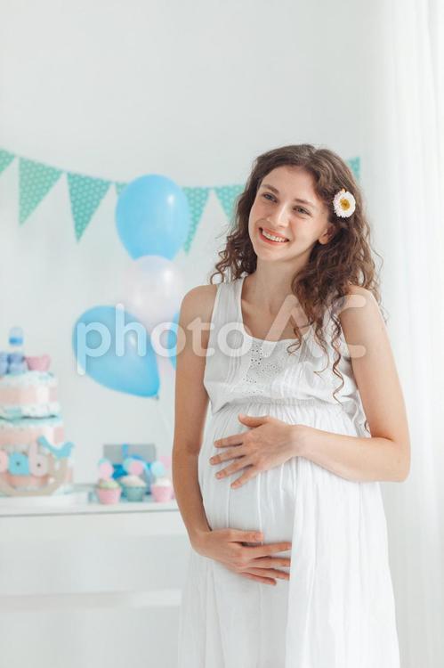 カメラ目線で笑顔でお腹を触る妊婦さん 女性,人物,風船の写真素材
