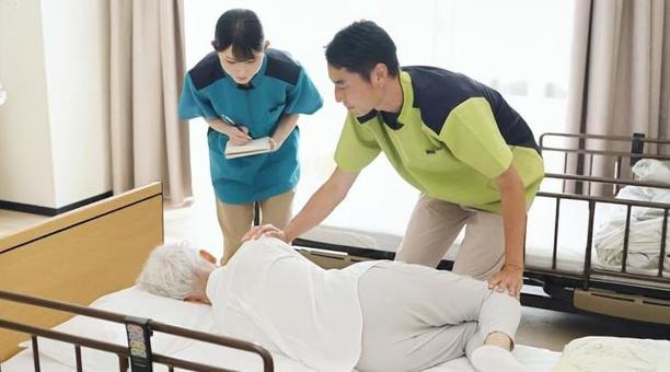 体位変換の指導を行うアジア人介護士 体位変換の指導を行うアジア人介護士 介護士,高齢者,研修の写真素材