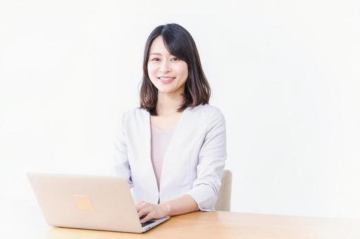 パソコン作業をする若い女性 パソコン作業をする若い女性の写真