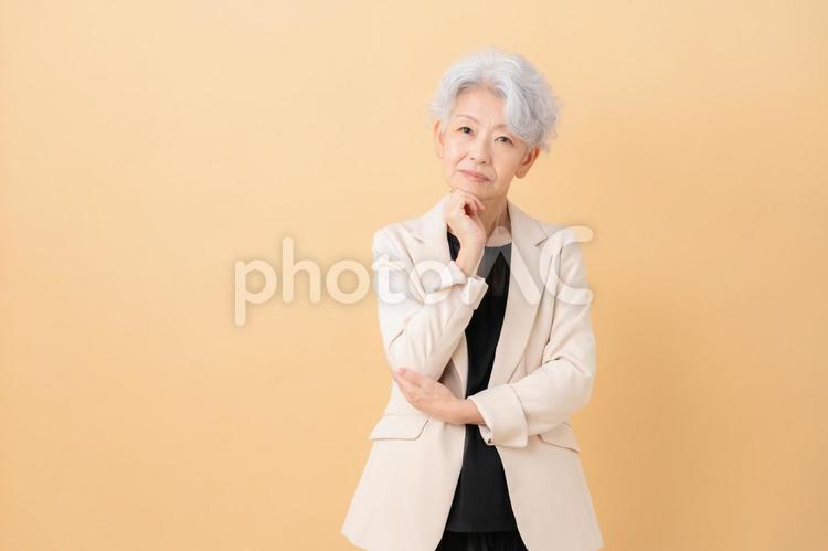 ベージュバックのシニアのビジネスウーマン ビジネス,女性,シニアの写真素材