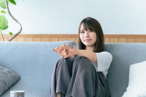 リビングのソファに座る笑顔の女性 リビングのソファに座る笑顔の女性 女性,ソファ,微笑むの写真素材