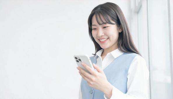 スマホを確認するビジネス女性 スマホを確認するビジネス女性の写真