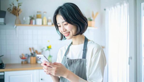 スマホでポイ活する笑顔の女性 スマホでポイ活する笑顔の女性の写真
