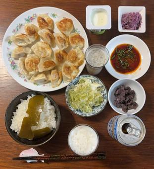 ご飯に餃子とラー油ニラ醤油たれなどの夕食の写真