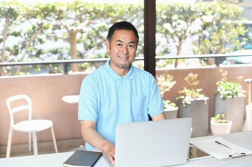 PCで事務作業をする笑顔のアジア人男性 PCで事務作業をする笑顔のアジア人男性 介護士,介護職,福祉の写真素材