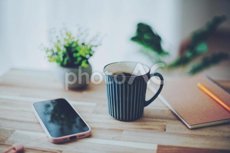 木製テーブルに置かれたコーヒーとスマホ 飲み物,マグカップ,コーヒーの写真素材