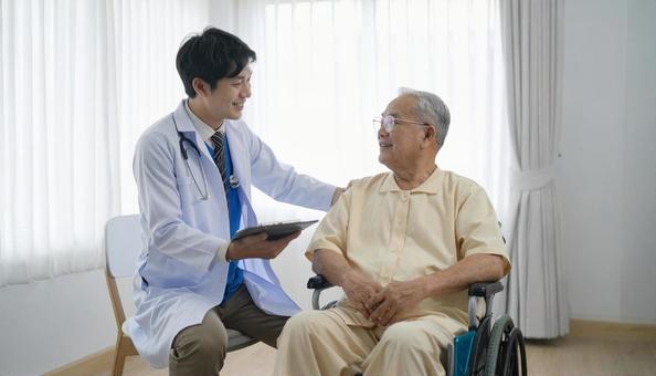 診察をする日本人男性医師 診察をする日本人男性医師の写真