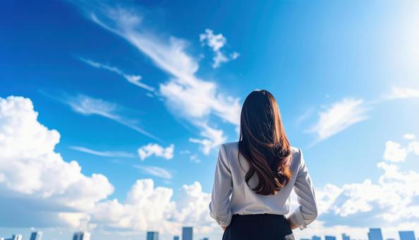 青空の下、遠くの景色を眺める女性の後ろ姿 青空の下、遠くの景色を眺める女性の後ろ姿の写真