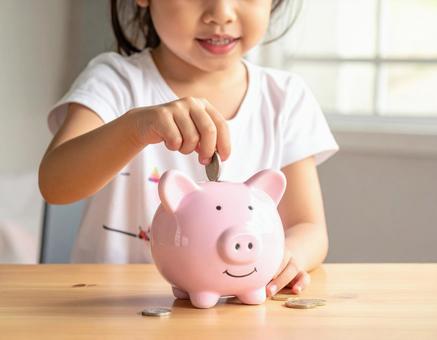 貯金する子ども 貯金する子どもの写真