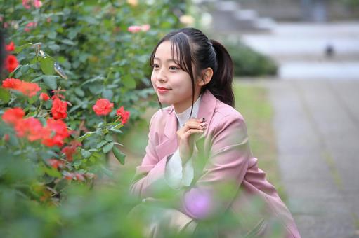 赤いバラを鑑賞する女性 女性,20代,公園の写真素材