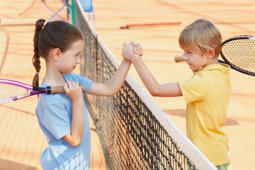 ネット越しに硬い握手をする対戦相手 男女,子供,外国人の写真素材