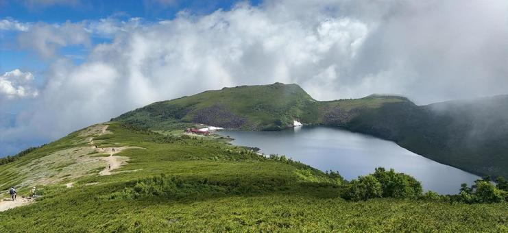 夏山に浮かぶ静かな湖と山小屋 夏山に浮かぶ静かな湖と山小屋の写真