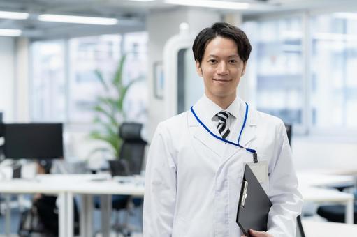 実験をする白衣の若い男性研究者 実験をする白衣の若い男性研究者の写真