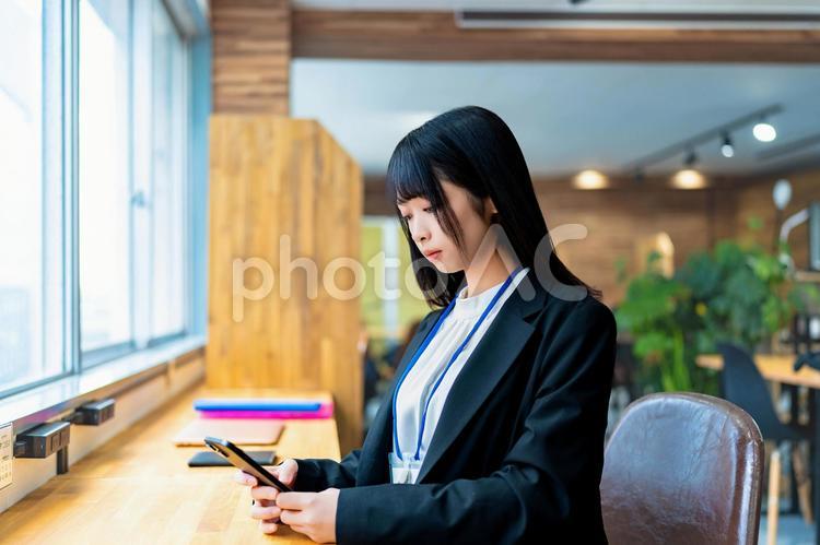 デスクで携帯を見るビジネスウーマン ビジネスウーマン,ビジネス,女性の写真素材