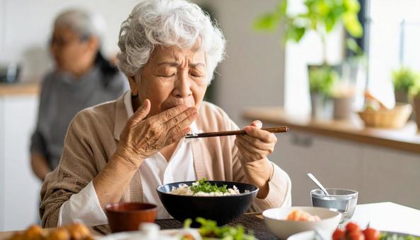 食事中、歯が痛む高齢者女性 食事中、歯が痛む高齢者女性の写真