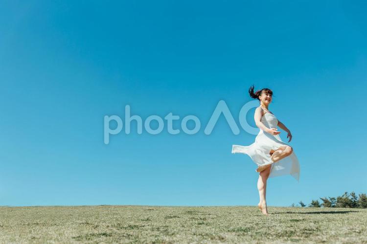空と白いワンピースの踊る女性 女性,空,美容の写真素材