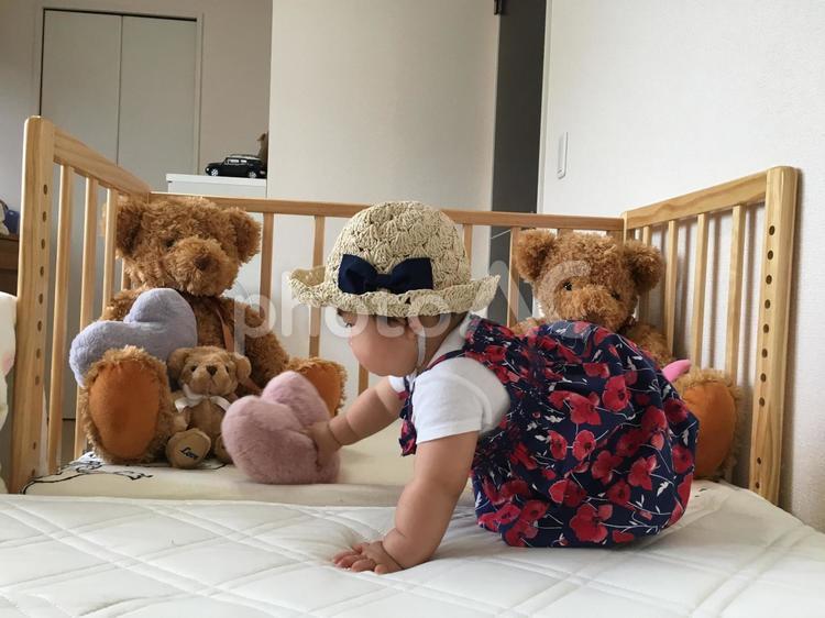 麦わら帽子をかぶる赤ちゃん 10ヶ月,9ヶ月,おもちゃの写真素材
