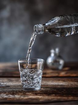 ペットボトルからコップへ水を注ぐ ペットボトルからコップへ水を注ぐの写真