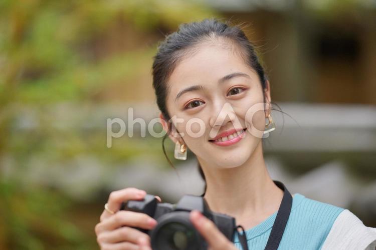 公園で一眼レフカメラを構えている女性 女子旅,女性,日本人の写真素材