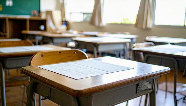プリントが置かれた教室の机 プリントが置かれた教室の机の写真