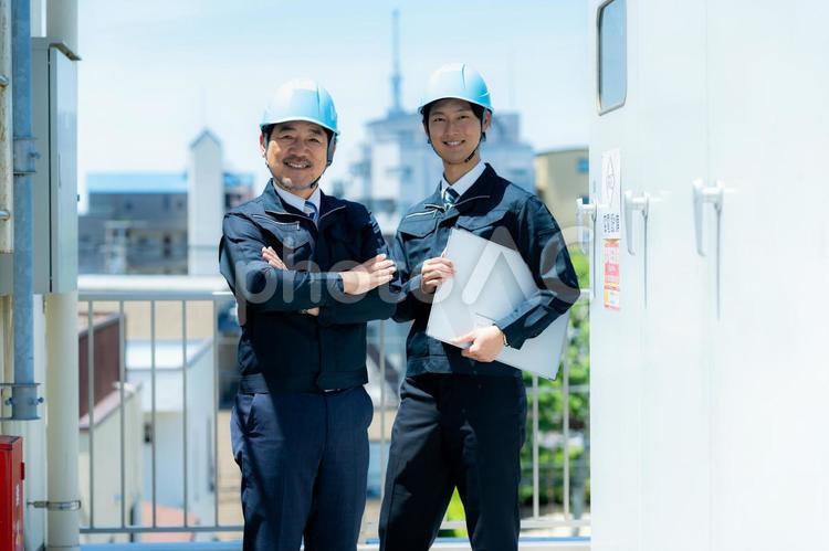 現場で打ち合わせする作業服のビジネスマン 作業服,笑顔,打ち合わせの写真素材