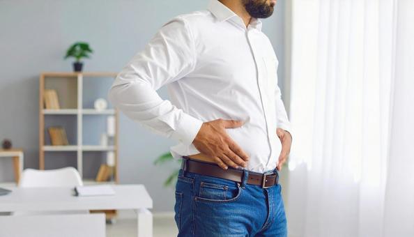 メタボリックなお腹に手を触れる男性 メタボリックなお腹に手を触れる男性の写真