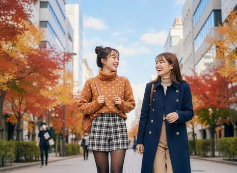 秋のストリートを友達と歩く女性 秋のストリートを友達と歩く女性の写真