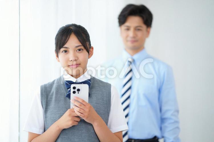 スマートフォンを持っている女子生徒と家庭教師 塾,人物,男性の写真素材