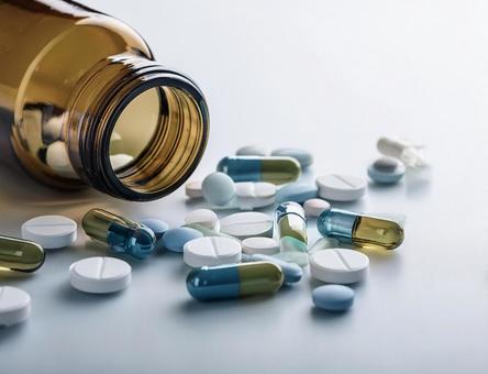 瓶からこぼれた錠剤の写真