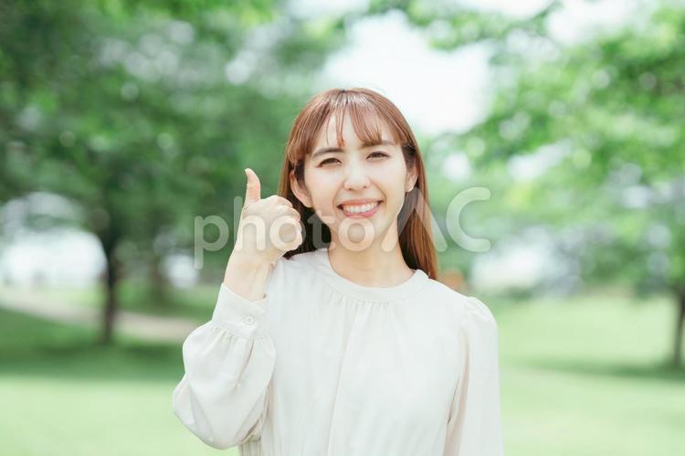 新緑のなかでGOODポーズをする女性 新緑,緑,自然の写真素材