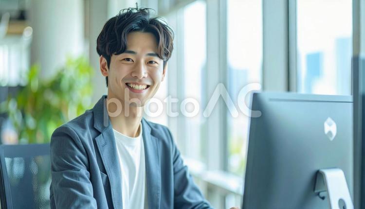 オフィスでパソコン操作をする男性 男性,パソコン,笑顔の写真素材