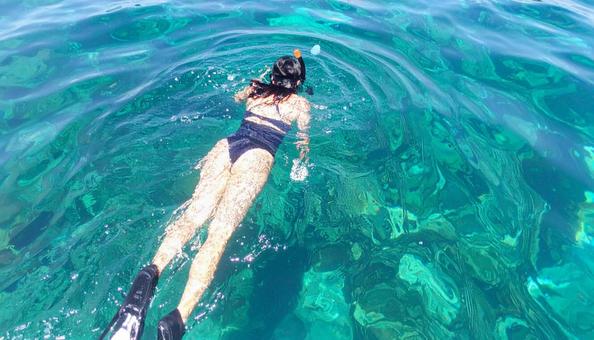 海でシュノーケリングをする女性の写真