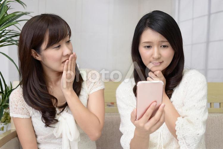 困惑した表情の二人の女性 女性,女,スマートフォンの写真素材