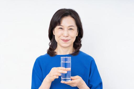 ミネラルウォーターを飲むミドルの女性 ミネラルウォーターを飲むミドルの女性 ミネラルウォーター,水,水分補給の写真素材