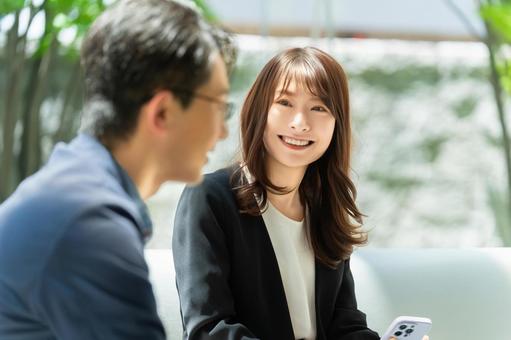 ミーティングをする男女2人のビジネスマン ミーティングをする男女2人のビジネスマンの写真