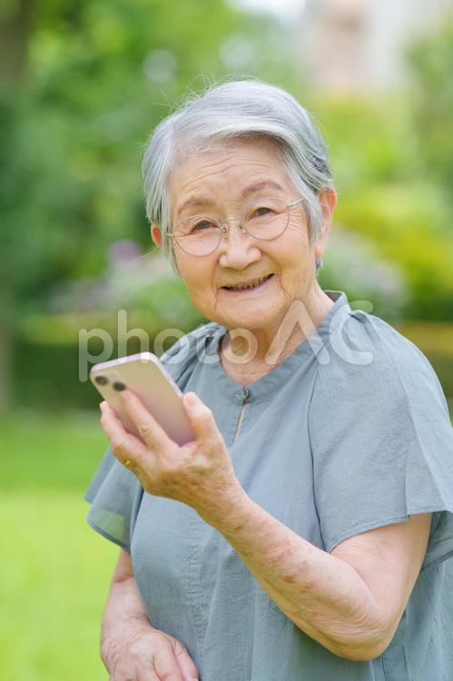 スマホを持ちカメラ目線の眼鏡女性 女性,スマートフォン,持つの写真素材