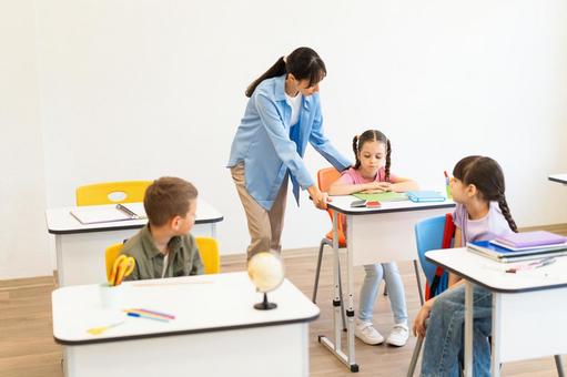 見守る先生と振り向く生徒たち 女性,女の子,男の子の写真素材
